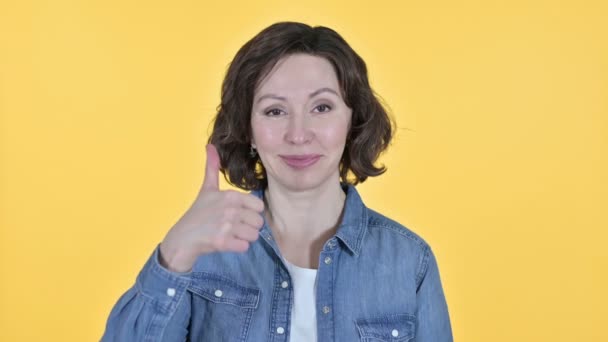 Tummen upp av positiv gammal kvinna, gul bakgrund — Stockvideo