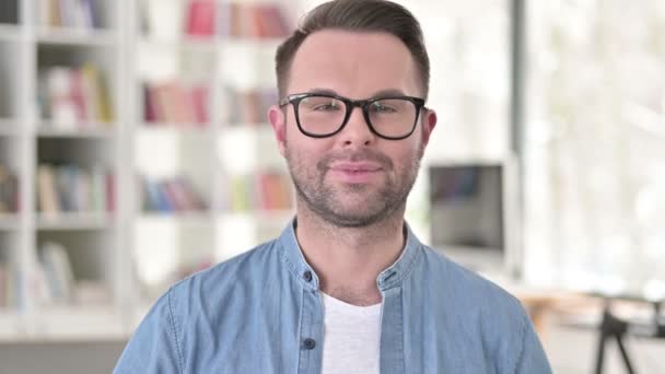 Hola, Hombre joven en gafas saludando a la cámara — Vídeos de Stock