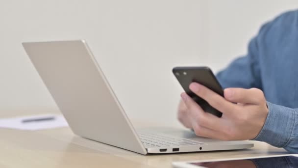 Blisko korzystania ze smartfona i laptopa przez człowieka — Wideo stockowe