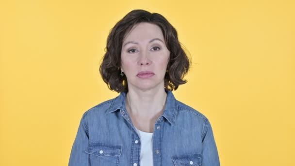 Sad Old Woman Looking at the Camera on Yellow Background — Stock Video