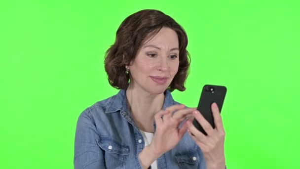 Stará žena slaví na Smartphone, zelené Chroma Key pozadí — Stock video