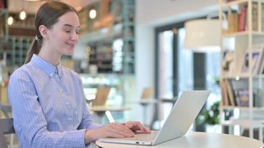 Video Chat on Laptop by Young Businesswoman in Cafe