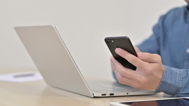 Close up of Man using Smartphone with Laptop — Stockvideo