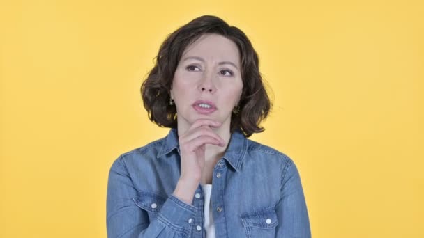 Znepokojená stará žena myšlení na žlutém pozadí — Stock video