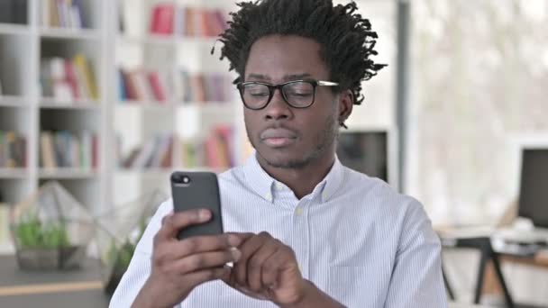 African Man Celebrating Success on Smartphone — Stock Video