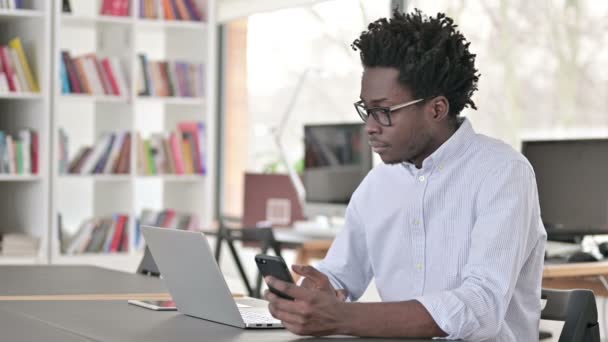 Empresário Africano usando Smartphone e Laptop — Vídeo de Stock