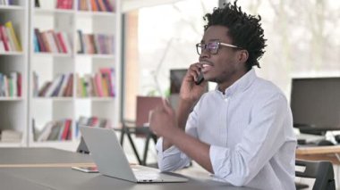Afrikalı İşadamı İş yerinde Akıllı Telefonla Konuşuyor