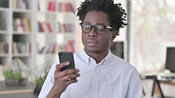Portrét mladého Afričana mluvícího na smartphonu — Stock video