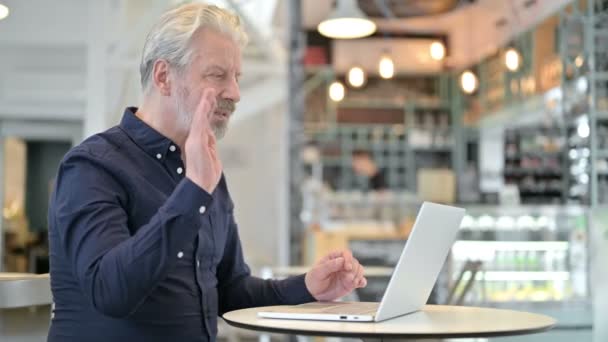 Chat de vídeo en el ordenador portátil por el Viejo en Café — Vídeos de Stock