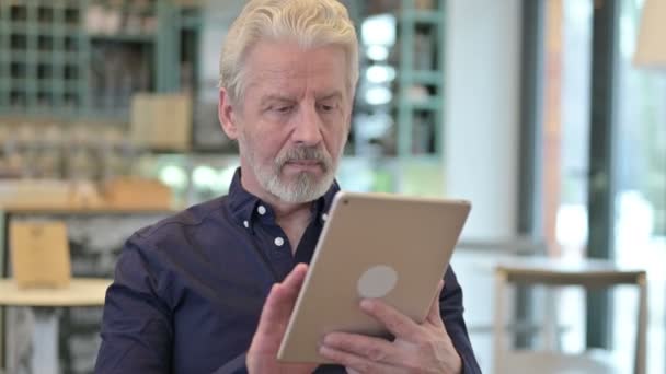 Portret van een professionele oude man met behulp van digitale tablet — Stockvideo