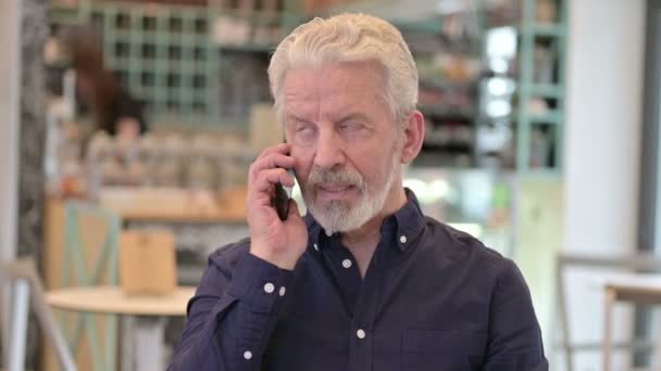 Portrét starého muže mluvícího na smartphonu — Stock video