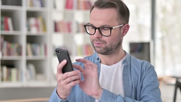 Young Man in Glasses Using Smartphone — Stock Video