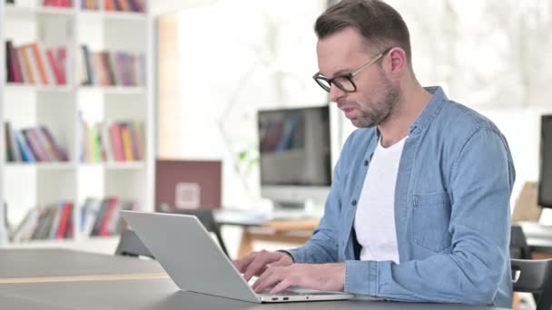 Junger Mann mit Brille hat Rückenschmerzen im Büro — Stockvideo