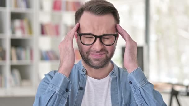 Hombre joven en gafas con dolor de cabeza — Vídeos de Stock