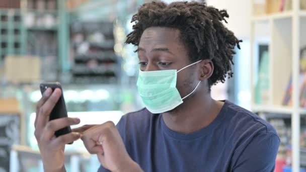 Portrait of African Man with Face Mask Using Smartphone — Stock Video