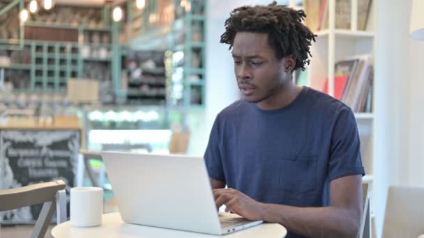 Succesvolle Afrikaanse man viert feest op laptop in Cafe — Stockvideo