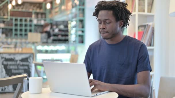 Uomo africano con mal di schiena lavorando sul computer portatile in Cafe — Video Stock