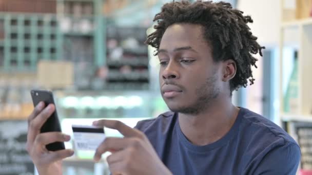 Porträt eines Afrikaners über das Online-Bezahlen auf dem Smartphone — Stockvideo