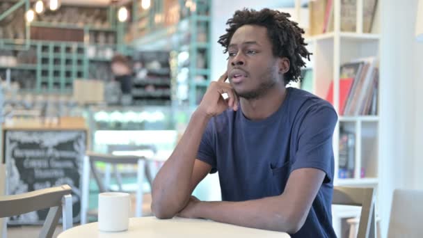 Töprengő afrikai férfi gondolkodás kávézóban — Stock videók