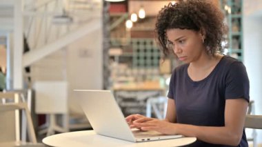 Dizüstü bilgisayarlı genç Afrikalı Kadın Duruyor ve Gidiyor 