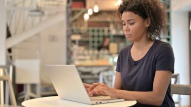 Dizüstü bilgisayarlı genç Afrikalı Kadın Parmak ile İşaret Ediyor 