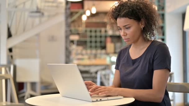 Laptop použití mladou africkou ženou při pohledu na kameru v kavárně — Stock video