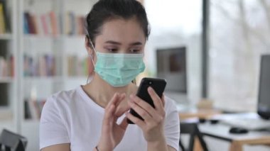 Akıllı telefon kullanan Asyalı Maskeli Kadın Portresi 