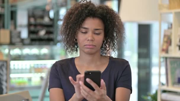 スマートフォンで祝う若いアフリカ人女性の肖像 — ストック動画