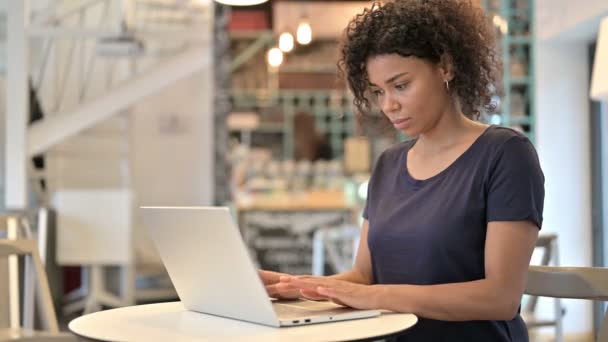 Jovem mulher africana profissional usando laptop no café — Vídeo de Stock