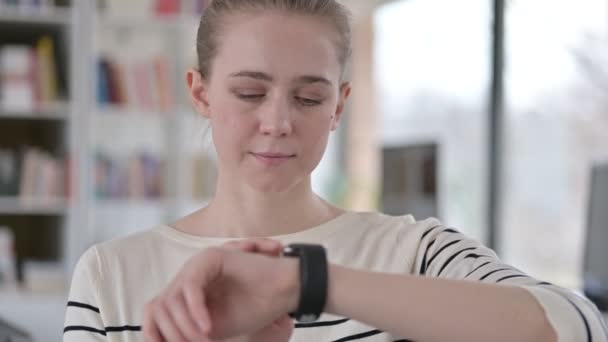 Retrato de una joven seria usando un reloj inteligente — Vídeo de stock