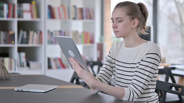Ψηφιακή Tablet χρήση από την όμορφη νεαρή γυναίκα στη βιβλιοθήκη — Αρχείο Βίντεο