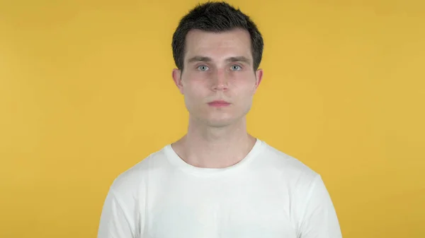 Nenucený muž při pohledu na fotoaparát izolovaný na žlutém pozadí — Stock fotografie