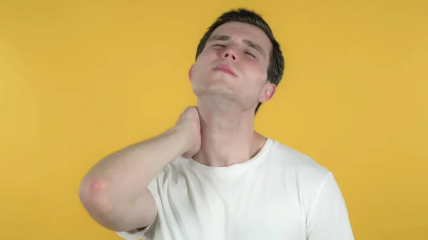 Nieformalny mężczyzna z bólem szyi, żółte tło — Zdjęcie stockowe