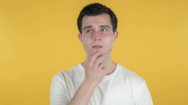 Sıradan bir adamın sarı arka planda izole edilmiş yeni bir fikri olduğunu düşünüyorum.