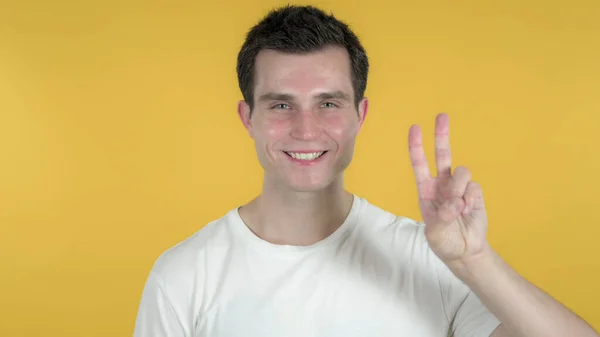 Sinal de Vitória por Homem Casual Isolado em Fundo Amarelo — Fotografia de Stock