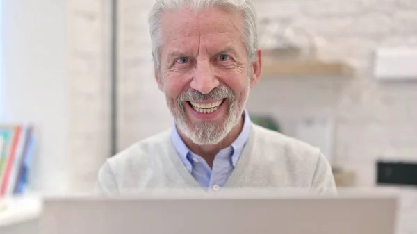 Großaufnahme eines lächelnden alten Mannes, der in die Kamera blickt — Stockfoto