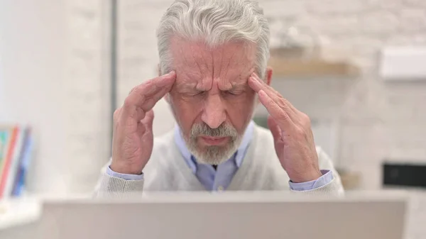 高齢者の閉鎖頭が痛いノートパソコンで作業 — ストック写真