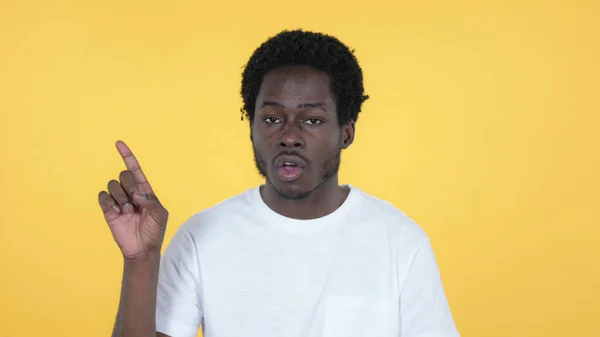Hombre africano casual agitando dedo para rechazar aislado sobre fondo amarillo —  Fotos de Stock