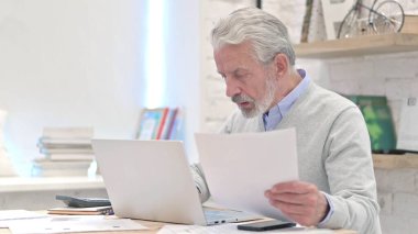 Kontrat ve evrak işlerinde çalışan kıdemli yaşlı adam.