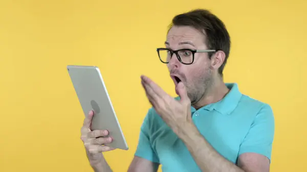 Lässiger Mann reagiert auf Verlust auf Tablet isoliert auf gelbem Hintergrund — Stockfoto