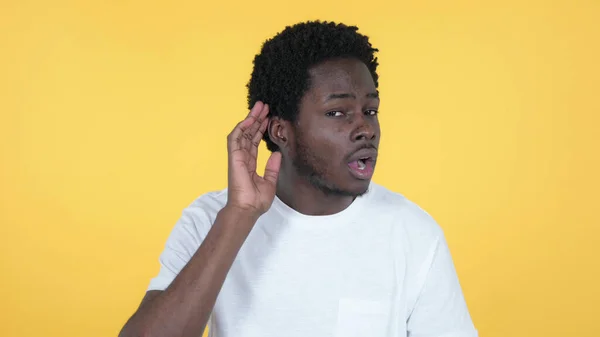 Casual African Man Listening Secret, isolerad på gul bakgrund — Stockfoto