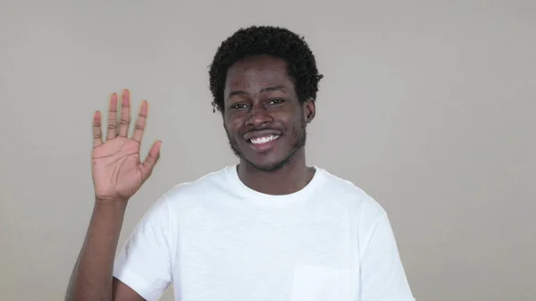 Alkalmi afrikai férfi integetett kézzel Üdvözöljük elszigetelt, a sárga háttér — Stock Fotó