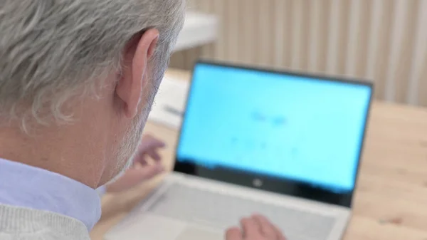 Zadní pohled seniora starého muže pomocí internetu na notebooku — Stock fotografie