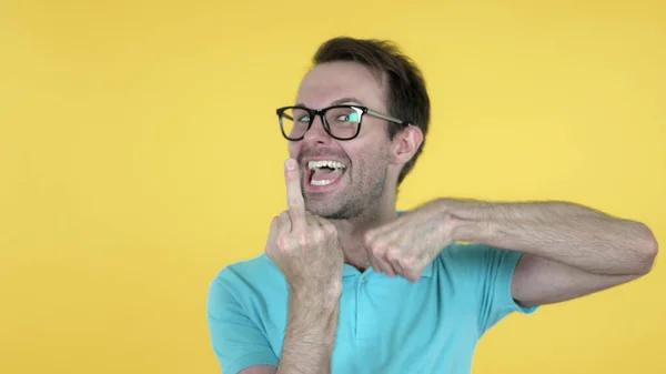 Grappig casual man toont middelvinger, gele achtergrond — Stockfoto