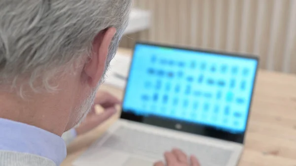 Zadní pohled staršího muže pracující na notebooku, Scrolling — Stock fotografie