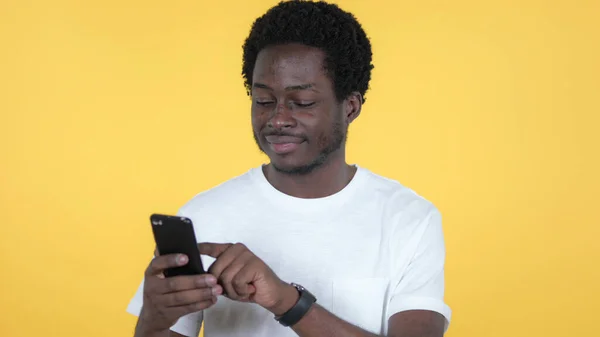 Casual Afrikaanse Man surfen Smartphone geïsoleerd op gele achtergrond — Stockfoto
