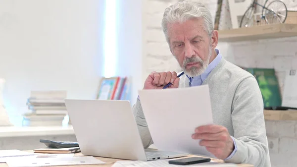 Senior Old Man Reading Documents at Work