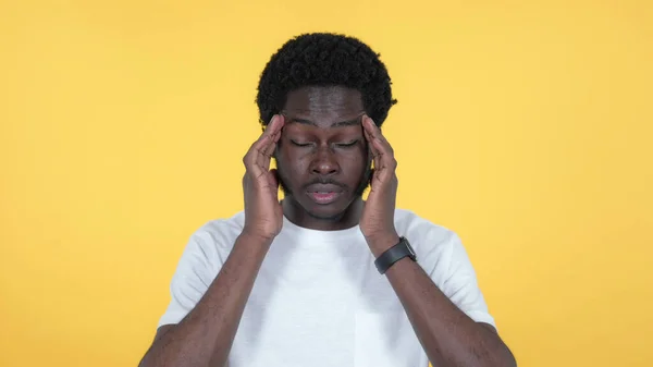 Příležitostné africký muž s bolestí hlavy, samostatný na žlutém podkladu — Stock fotografie