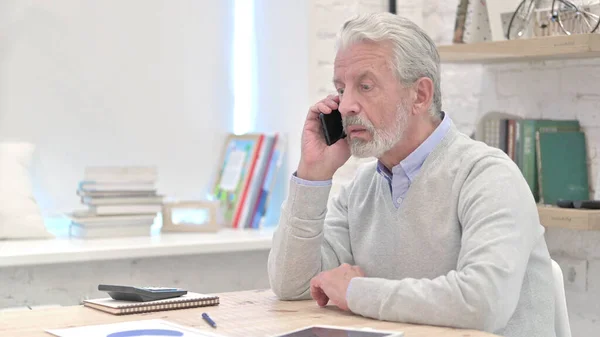 Vieil homme âgé parlant au téléphone au travail — Photo