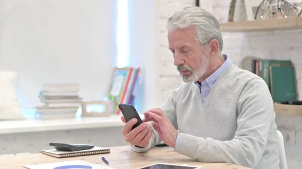 Vieil homme âgé utilisant Smartphone au travail — Photo